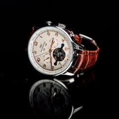 A chronograph wristwatch with a brown leather strap.